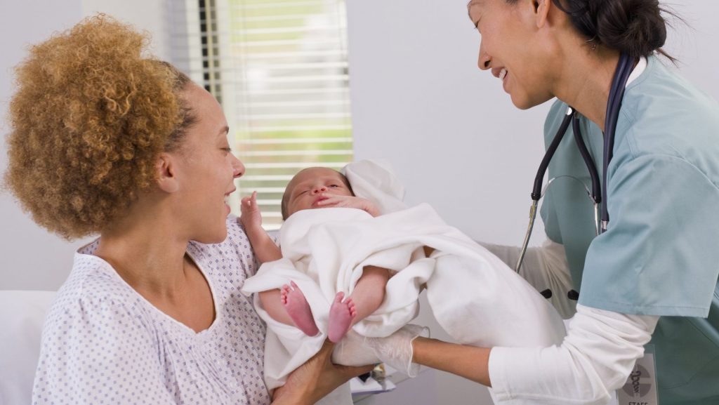 Doctor Handing A Newborn To His Mom