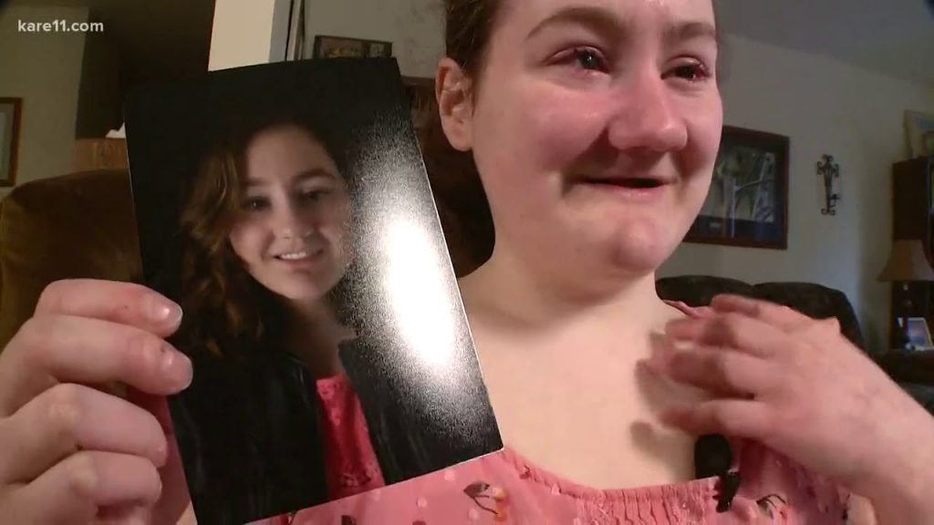 Gabby Holding Her Senior Picture Showing Her With Teeth