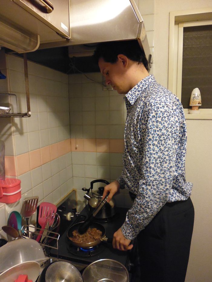 A Man Stands Cooking at a Stove