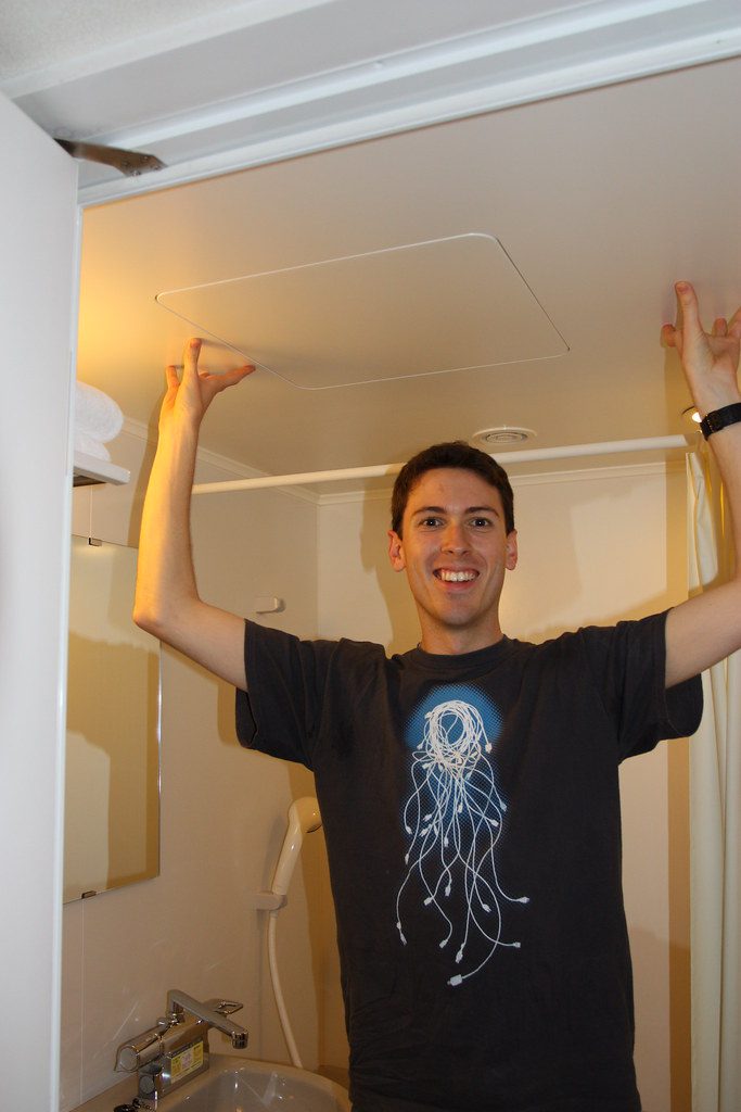 A Man Touches the Ceiling of his Hotel Bathroom