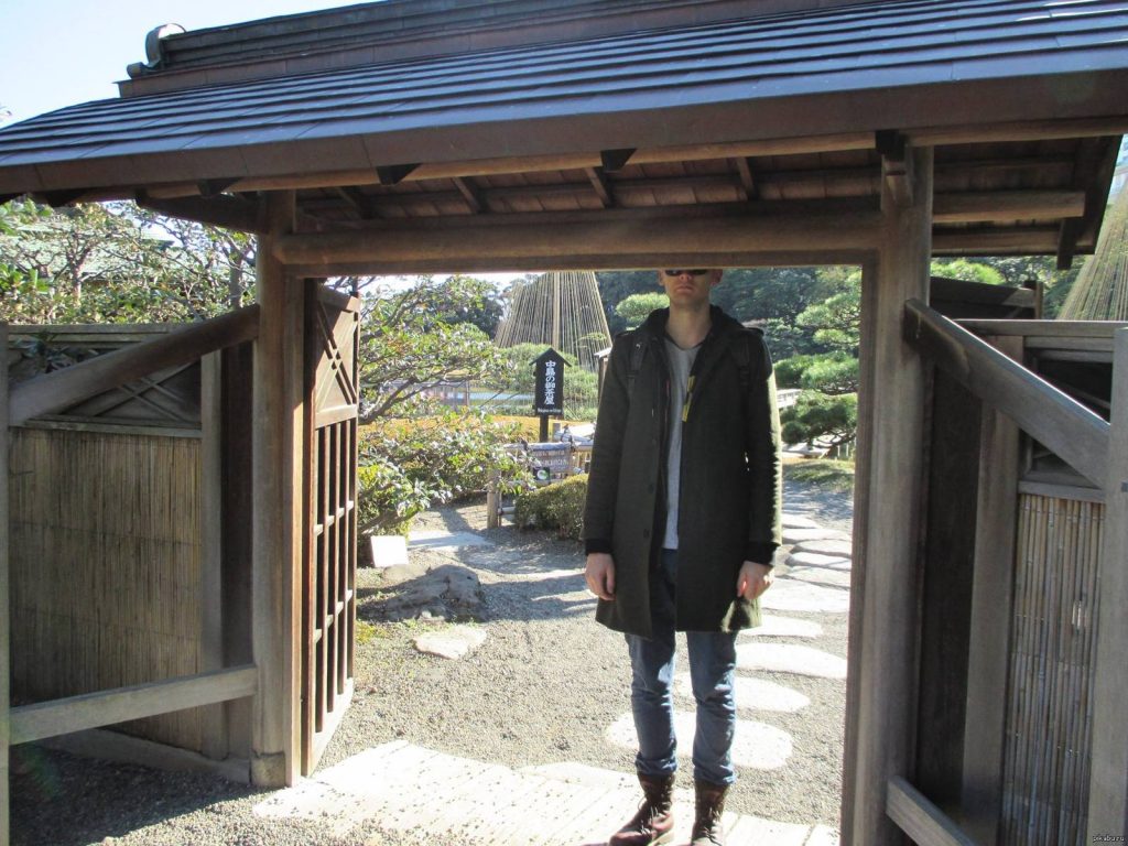 Man Standing at Temple Entrance