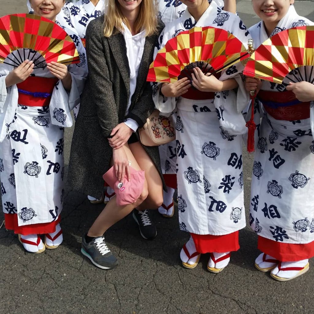 Woman Stoops with Women in Traditional Dress