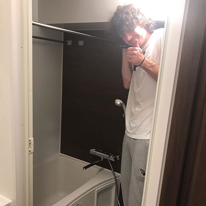 Man Stands in Hotel Bathroom