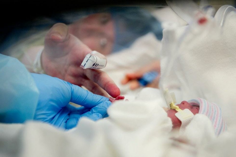 Lauren Perkins Touching The Finger Of One Of Her Newborns